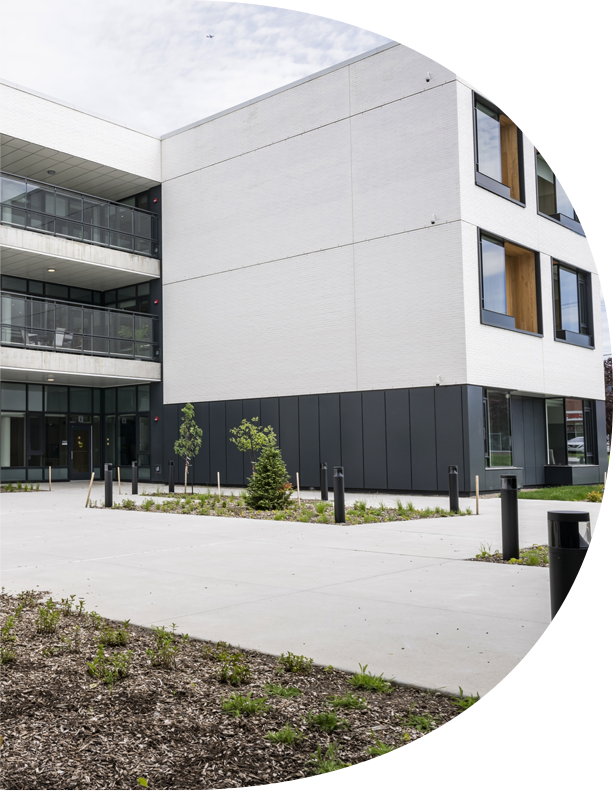 Bâtiment commercial en béton avec façade blanche et aménagement extérieur